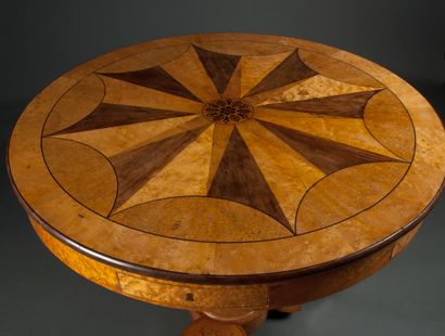 null A tripod pedestal table in light wood veneer, top in marquetry with a radiating...