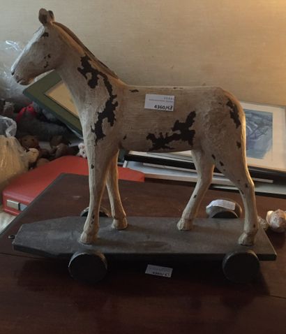 null Pulling toy in the shape of a horse, resting on a base with four wheels (accidents...