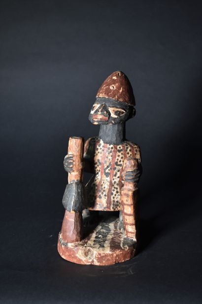 null SMALL Yoruba FETICHE in painted wood holding a pestle. Height: 29 cm