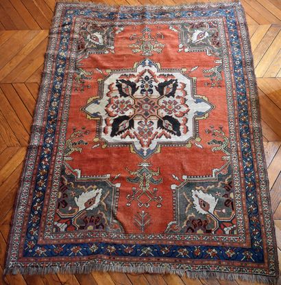 null Oriental carpet with red background, white central medallion and green spandrels...