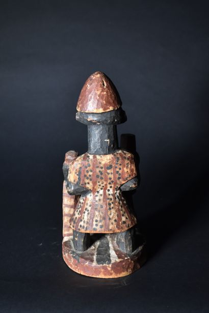 null PETIT FETICHE Yoruba en bois peint tenant un pilon. Haut. 29 cm