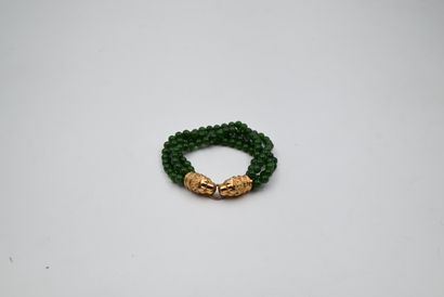 null BRACELET with four rows of green bakelite beads. Clasp in gold representing...
