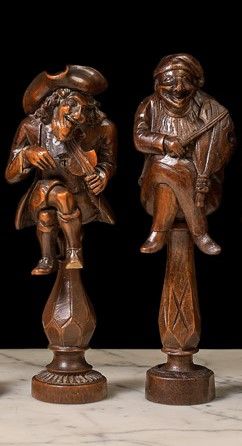 null Two cage nutcrackers depicting seated fiddlers with crossed legs. One wearing...