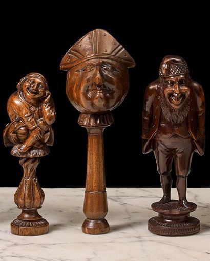 null Three wooden cage nutcrackers depicting a man seated on a column, a man's head...