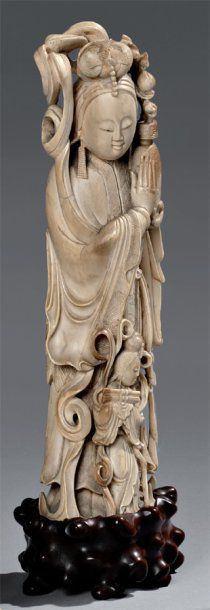 null Beau sujet en ivoire représentant une divinité tenant un vase à offrandes, accompagnée...