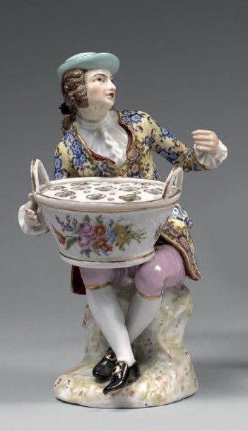 null Statuette en porcelaine genre Saxe représentant un personnage assis au panier....