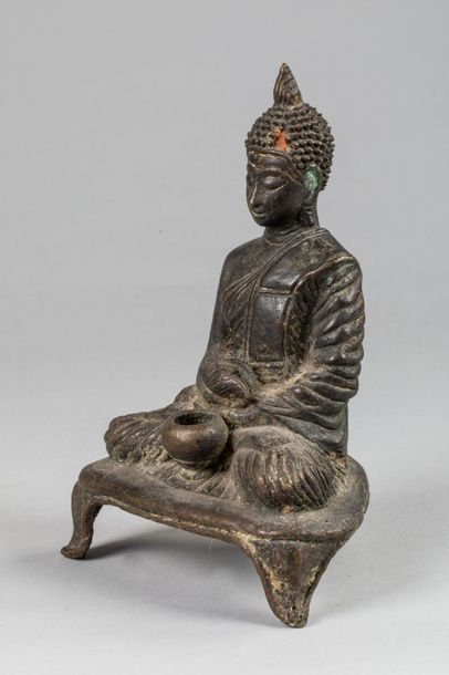 null Buddha 

En bronze, Buddha assis sur un socle tripode vêtu de la robe monastique...