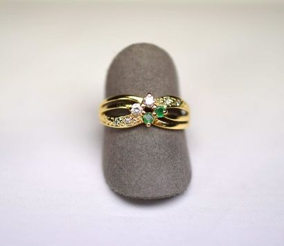 null Yellow gold ring decorated with 2 round emeralds enhanced with zirconium oxides....