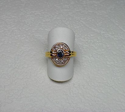 null BAGUE en or jaune centrée en clos d'un saphir ovale entouré par 2 rangées de...