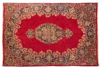 null Important KIRMAN with plain ruby field with a very large central medallion in...