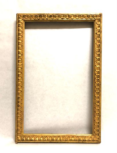 null A molded and carved wooden frame decorated with a frieze of heart-shaped stripes....