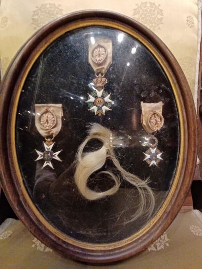 null OVAL FRAME with 3 decorations and a lock of hair.