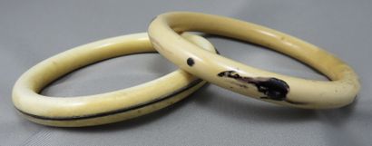  2 Bracelets Joncs 
 en ivoire, pour l'un avec incrustation d'un filet de corne,...