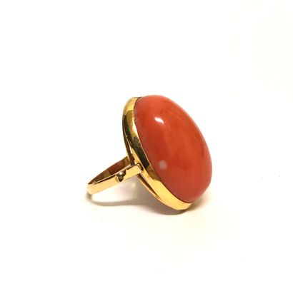 null Yellow gold ring 18K (750 thousandths) set with a large oval coral, cabochon....