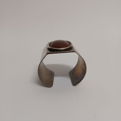 null BRACELET cuff adorned with a cabochon stone tinted red.