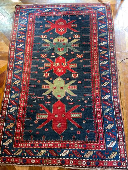 null 
Oriental wool carpet with red and green geometric decoration on a blue background...