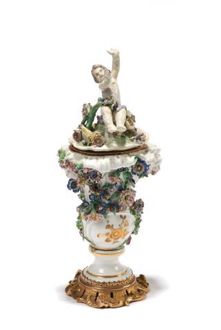 null Covered vase in polychrome soft porcelain with flowers in relief. The lid surmounted...