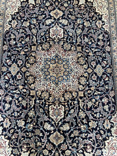 null IRAN, Persia. Naïn wool carpet decorated with floral scrolls on a navy blue...