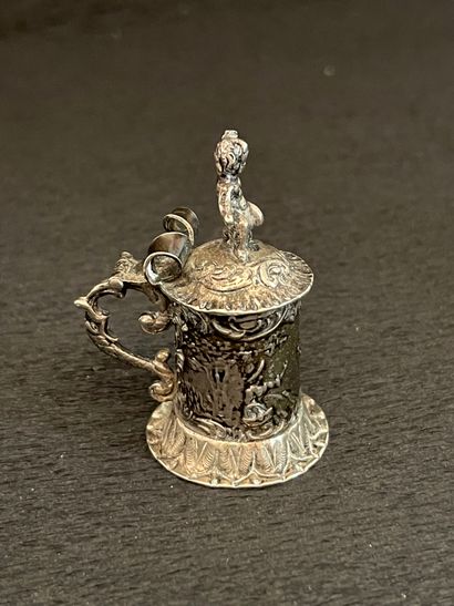 null Miniature silver mug decorated with a gallant scene, topped by a puto. English...