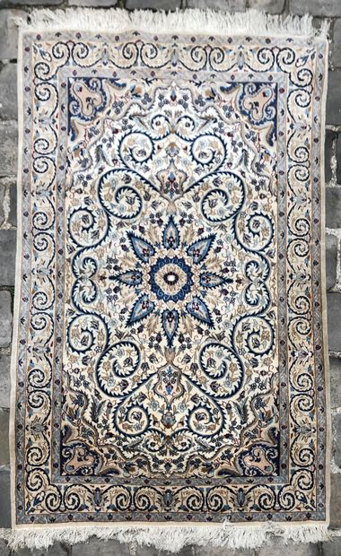 null IRAN, Perse. Tapis Naïn en laine à décor de rinceaux fleuris sur fond beige,...