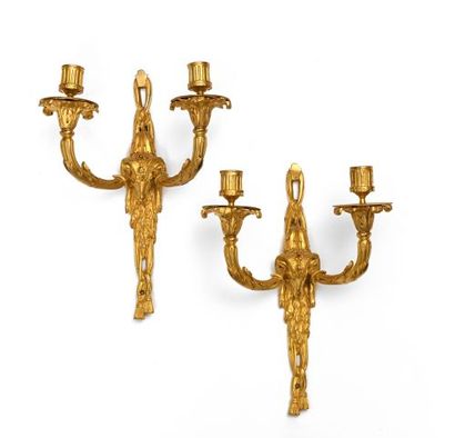 null Pair of two lights sconces in chased and gilt bronze decorated with rams' heads...