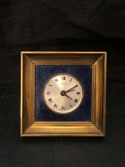 null CARTIER. Clock in gilded metal and lapis lazuli.