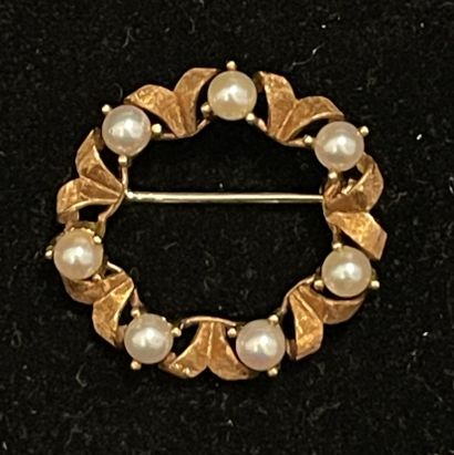 null Round brooch in 750°/00 yellow gold forming a ribboned crown alternating with...