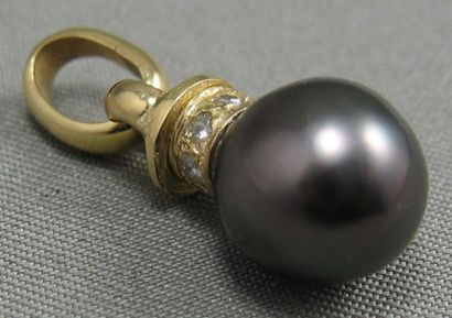null Pendentif en or, orné d'une perle noire de Tahiti légèrement baroque, la bélière...