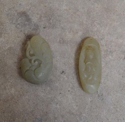 null LOT de deux GALETS sculptés en jade vert clair, l'un à décor de poisson et l'autre...