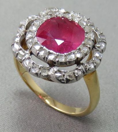 null BAGUE en or 18k et platine, ornée d'un rubis de synthèse dans un double entourage...