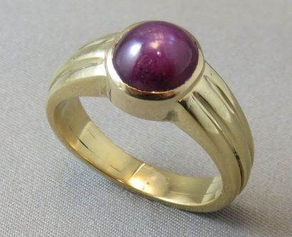 null Bague Jonc en or 18k cannelé, ornée d'un cabochon en rubis étoilé en serti clos....