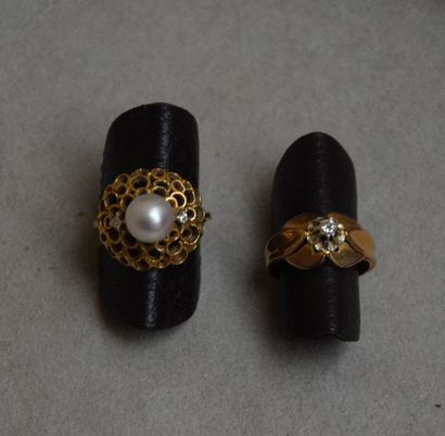 null DEUX BAGUES en or, une à jupe ajourée sertie d'une perle flanquée de deux brillants,...