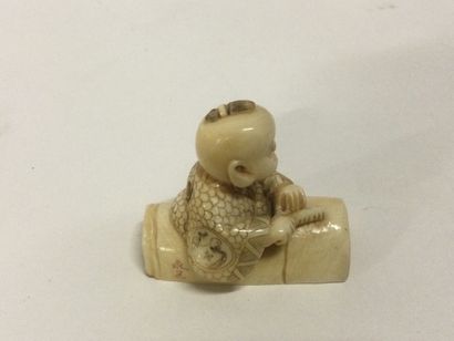 null JAPON. Netsuké en ivoire sculpté figurant un personnage sur un tonneau cachant...