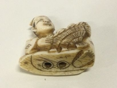 null JAPON. Netsuké en ivoire sculpté figurant un personnage tenant une corbeille,...