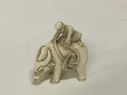 null JAPAN. A carved ivory netsuke with a figure on an ox, signature on the bottom,...