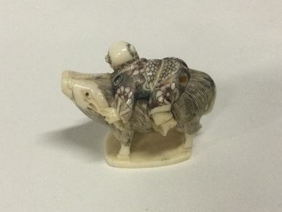 null JAPAN. A carved ivory netsuke showing a character riding an animal, polychrome...