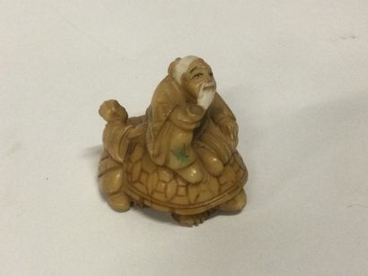 null JAPON. Netsuké en ivoire sculpté figurant un vieil homme sur une tortue, décor...