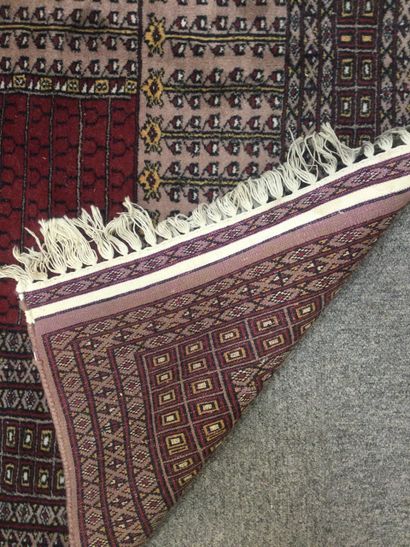 null PAKISTAN, Hand-knotted prayer rug in wool with geometrical patterns in burgundy...
