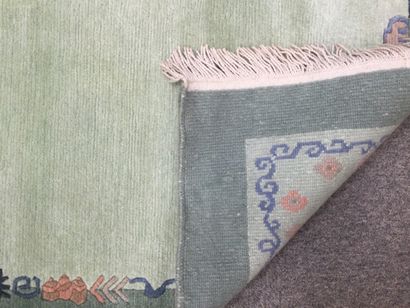 null NEPAL, Tapis noué main en laine tuftée à décor d'une frise sur fond vert amande,...