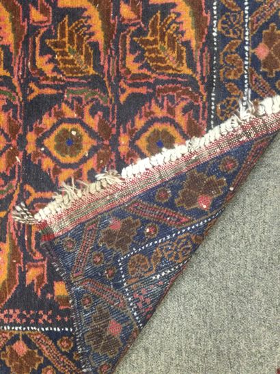null IRAN, tapis en laine noué main à décor de motifs stylisés sur fond bleu. Usures...