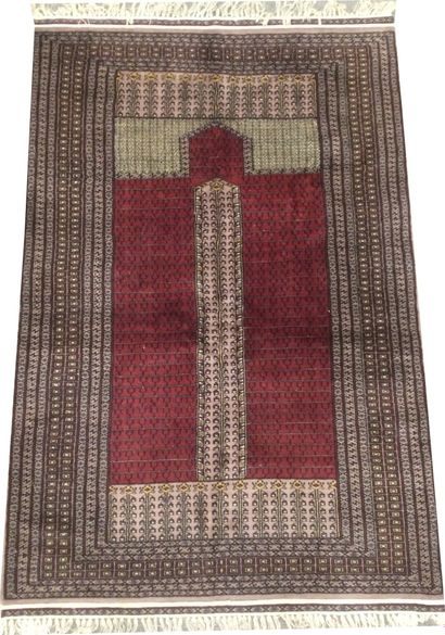 null PAKISTAN, Hand-knotted prayer rug in wool with geometrical patterns in burgundy...