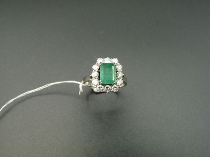 null 18K (750/oo) white gold ring centered on a rectangular cut emerald weighing...