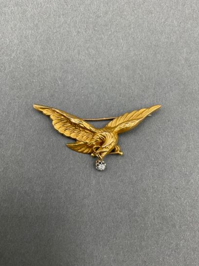 null BROCHE en or jaune 18K 750/°° figurant un aigle aux ailes déployées et tenant...