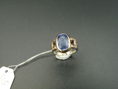 null 18K (750/oo) two-tone gold ring centered on an oval sapphire weighing approximately...