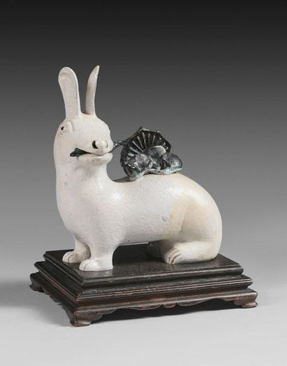 null 125- White and green glazed ceramic subject, representing a seated rabbit holding...