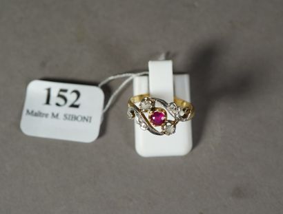 null 152- Bague en or jaune 18K, enroulement encadrant un rubis rond épaulé de diamants...