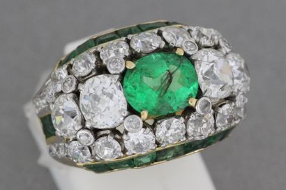 null 135- Gold and platinum ring set with an emerald and two diamonds surrounded...