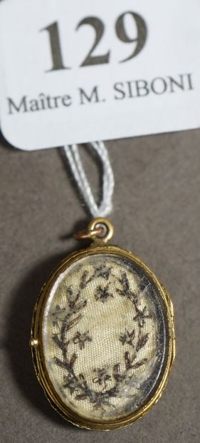 null 129- Petit pendentif reliquaire ouvrant en or jaune orné d'une pensée brodée...