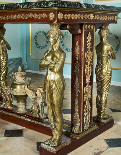  26- Table de milieu en acajou à riche décor de bronzes tels que cariatides, urne...