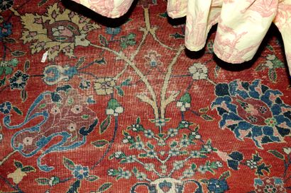 null 14- Important tapis Persan à décor de fleurs stylisées sur fond rouge. Usures...